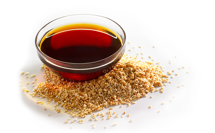 sesamea oil with a pile of seeds 1 Organic Toasted Sesame Oil image